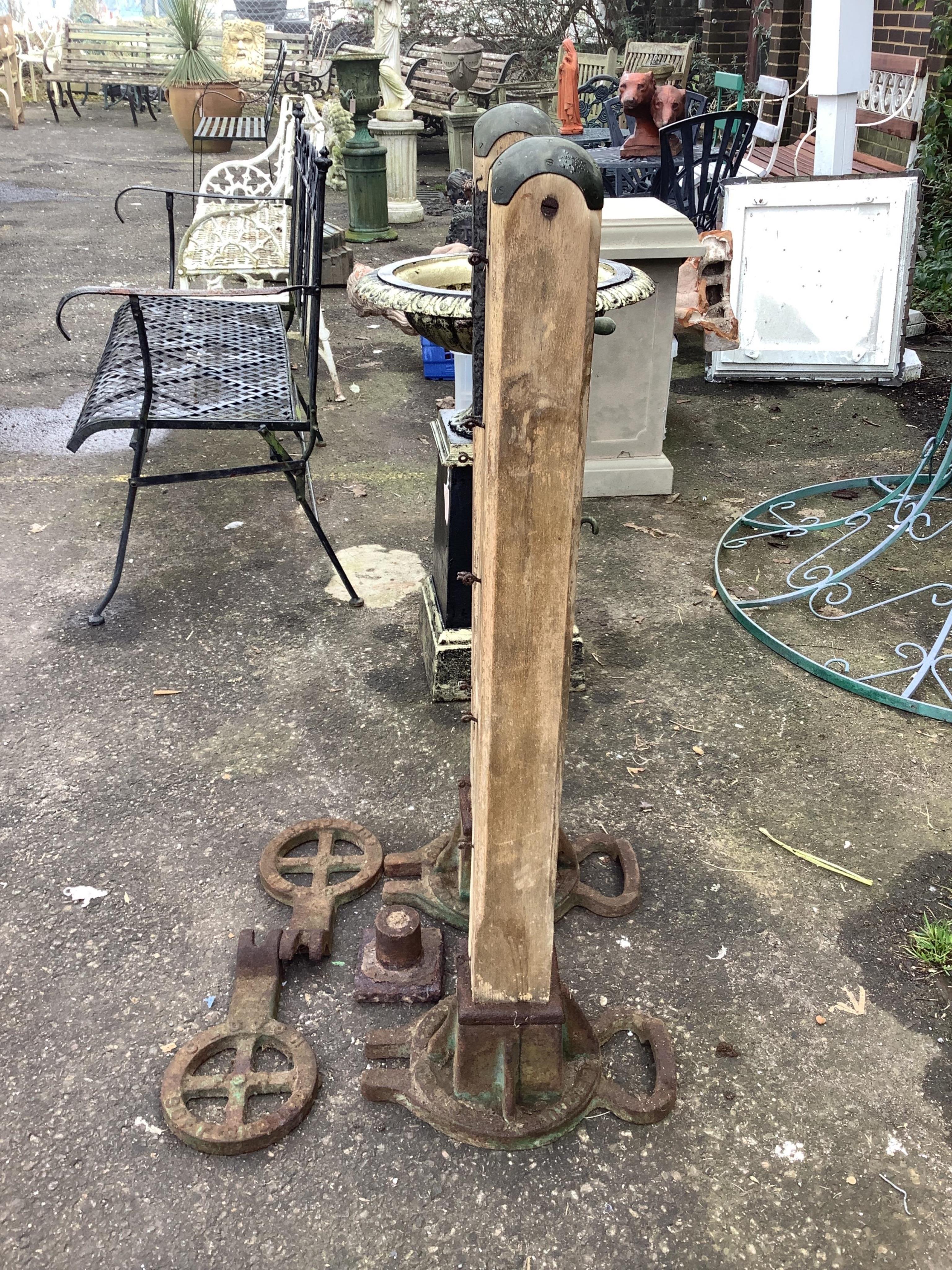 A pair of Victorian cast iron and hardwood tennis posts with ground anchors, height 109cm. Condition - poor to fair